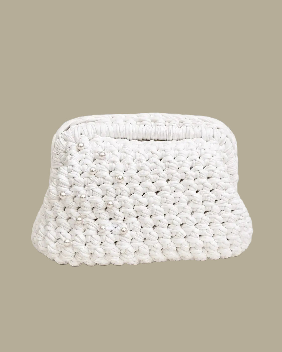 A small white woven clutch bag with a textured crochet pattern and small pearl-like embellishments, set against a solid beige background.